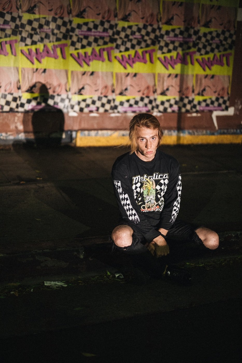 man sitting on concrete pavement