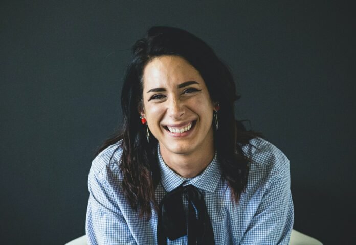 smiling woman in white and black checkered dress shirt