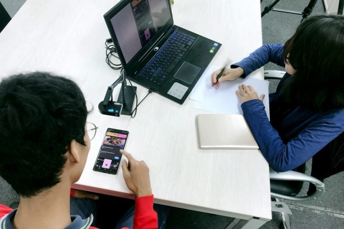 person in blue long sleeve shirt using black laptop computer