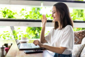 Young woman raising her hand during an online ADHD coaching session about causes and contributing factors